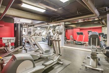 a gym with a red wall and various exercise equipment